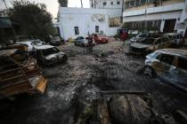 Palestinian men look over the site of a deadly explosion at al-Ahli Hospital in Gaza City, Wedn ...