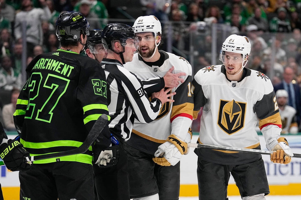 Hockey linesman Ben O'Quinn, second from left, restrains Vegas Golden Knights defenseman Nicola ...