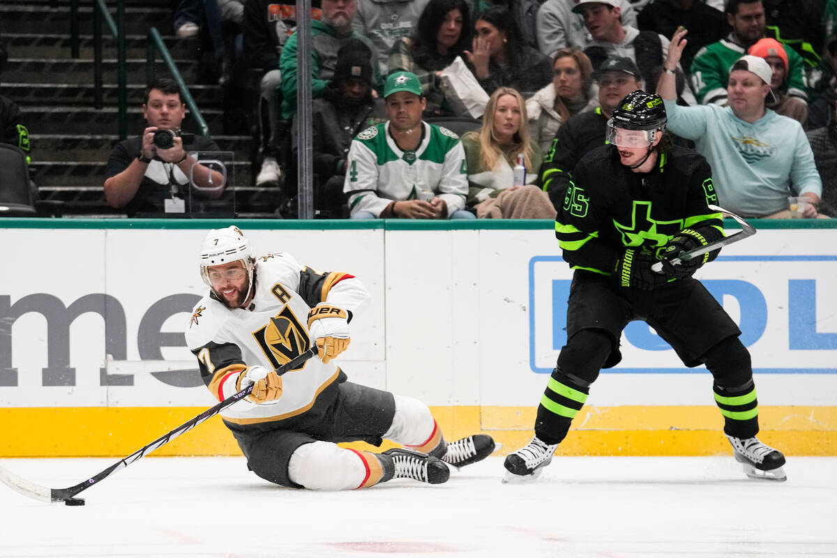 Vegas Golden Knights defenseman Alex Pietrangelo, left, tries to control the puck while being c ...