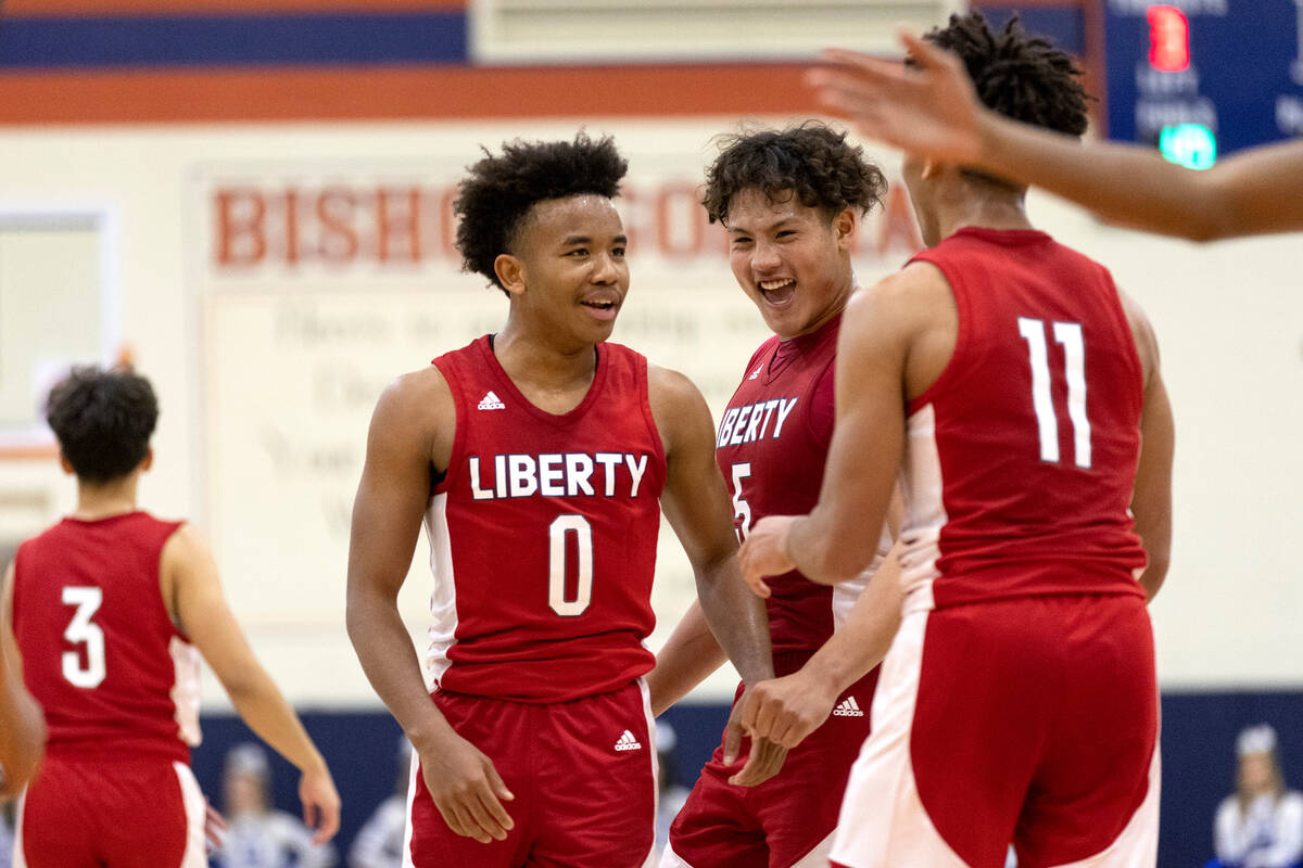 Liberty’s Tyus Thomas (0), Andre Porter (5) and Dedan Thomas Jr. celebrate a foul called ...