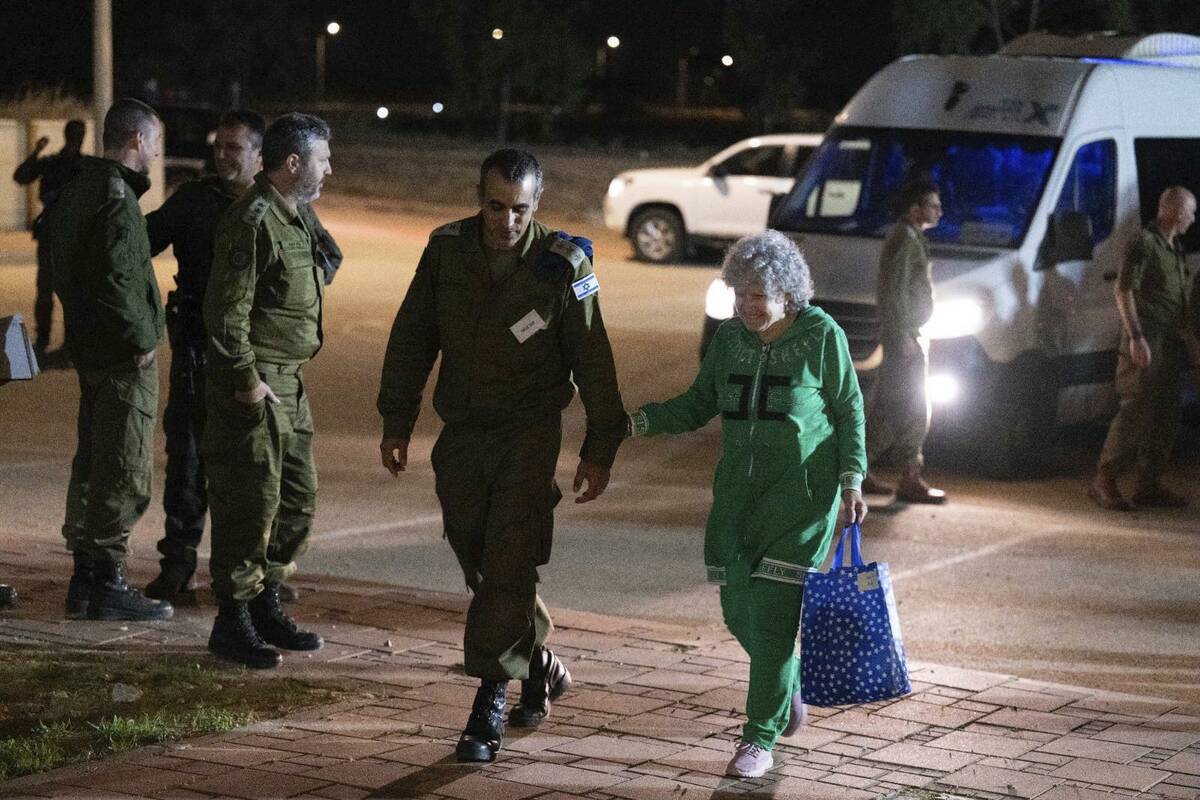 Ruth Munder, a released Israeli hostage, walks with an Israeli soldier shortly after her arriva ...