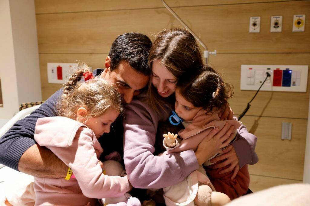 Aviv Asher, 2,5-year-old, her sister Raz Asher, 4,5-year-old, and mother Doron, react as they m ...