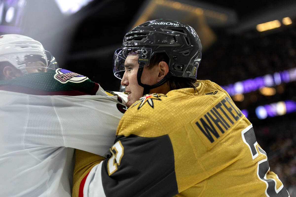 Golden Knights defenseman Zach Whitecloud (2) fights Coyotes left wing Lawson Crouse (67) durin ...