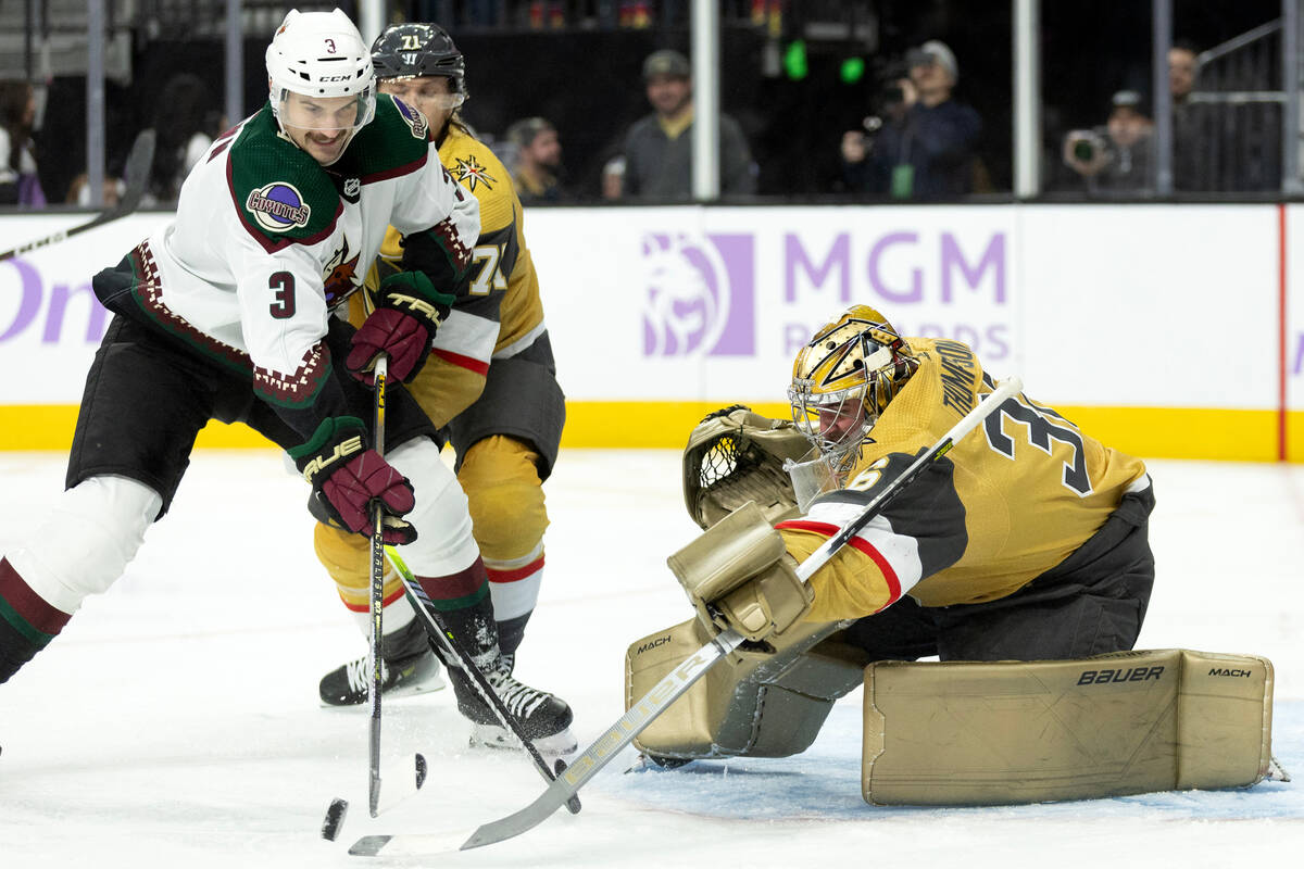 Golden Knights goaltender Logan Thompson (36) saves the puck from a shot by Coyotes defenseman ...