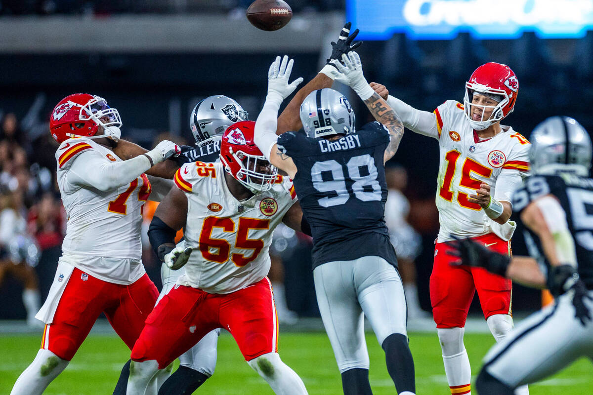 Raiders defensive end Maxx Crosby (98) reaches to block a pass by Kansas City Chiefs quarterbac ...