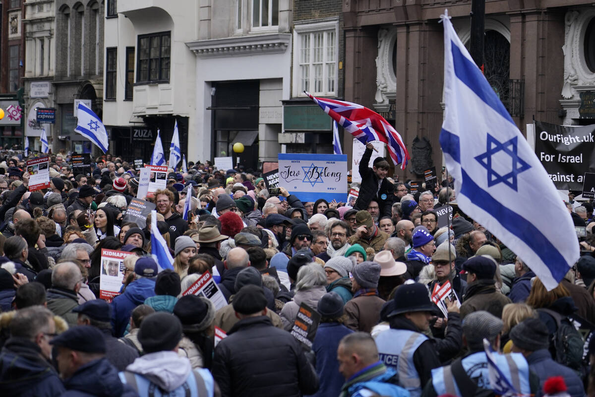 Protesters holding placards flags and banners, including the flag of Israel, during an anti-Sem ...