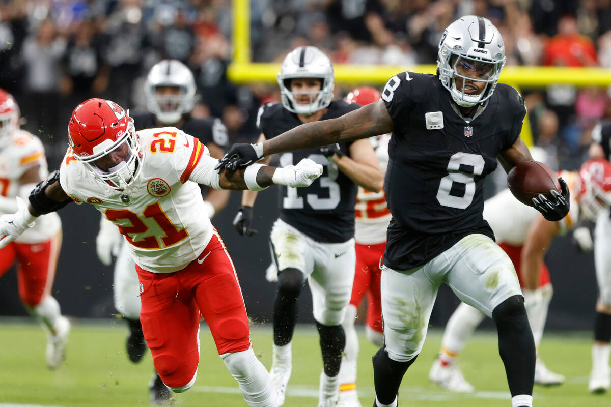 Raiders running back Josh Jacobs (8) pushes Kansas City Chiefs safety Mike Edwards (21) away as ...