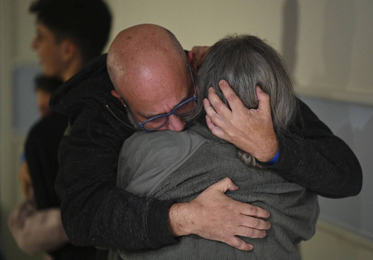 This handout photo provided by Haim Zach/GPO shows Sharon Hertzman, right, hugging her husband ...