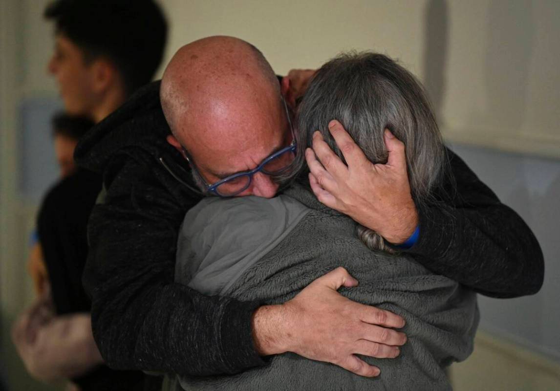 This handout photo provided by Haim Zach/GPO shows Sharon Hertzman, right, hugging her husband ...