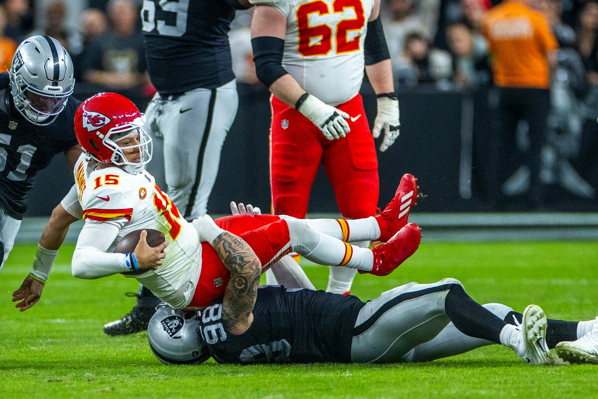 Kansas City Chiefs quarterback Patrick Mahomes (15) is sacked by Raiders defensive end Maxx Cro ...