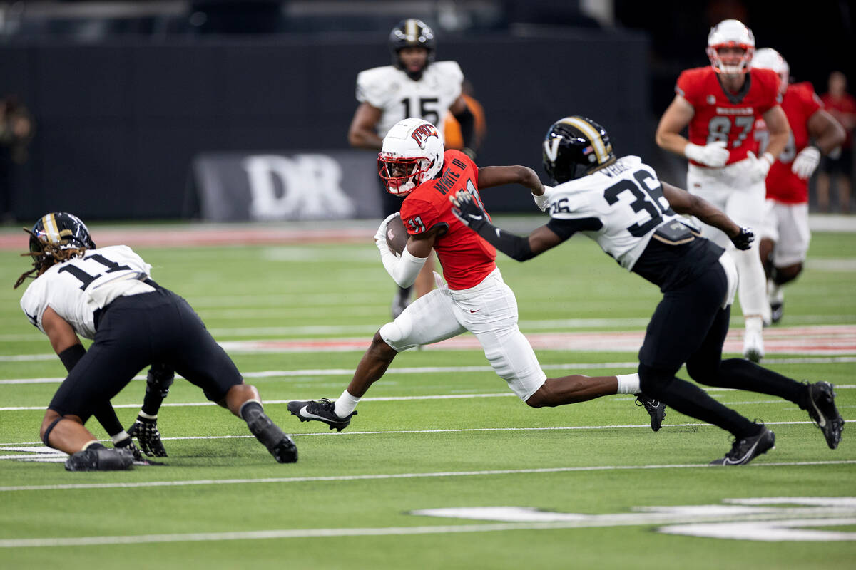 UNLV wide receiver Ricky White (11) runs the ball while Vanderbilt defensive end Darren Agu (11 ...