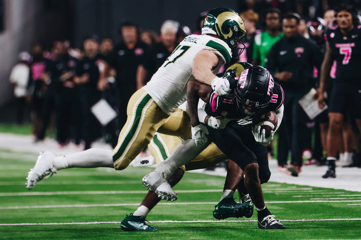 UNLV wide receiver Ricky White (11) makes his way through Colorado State defenders during a gam ...