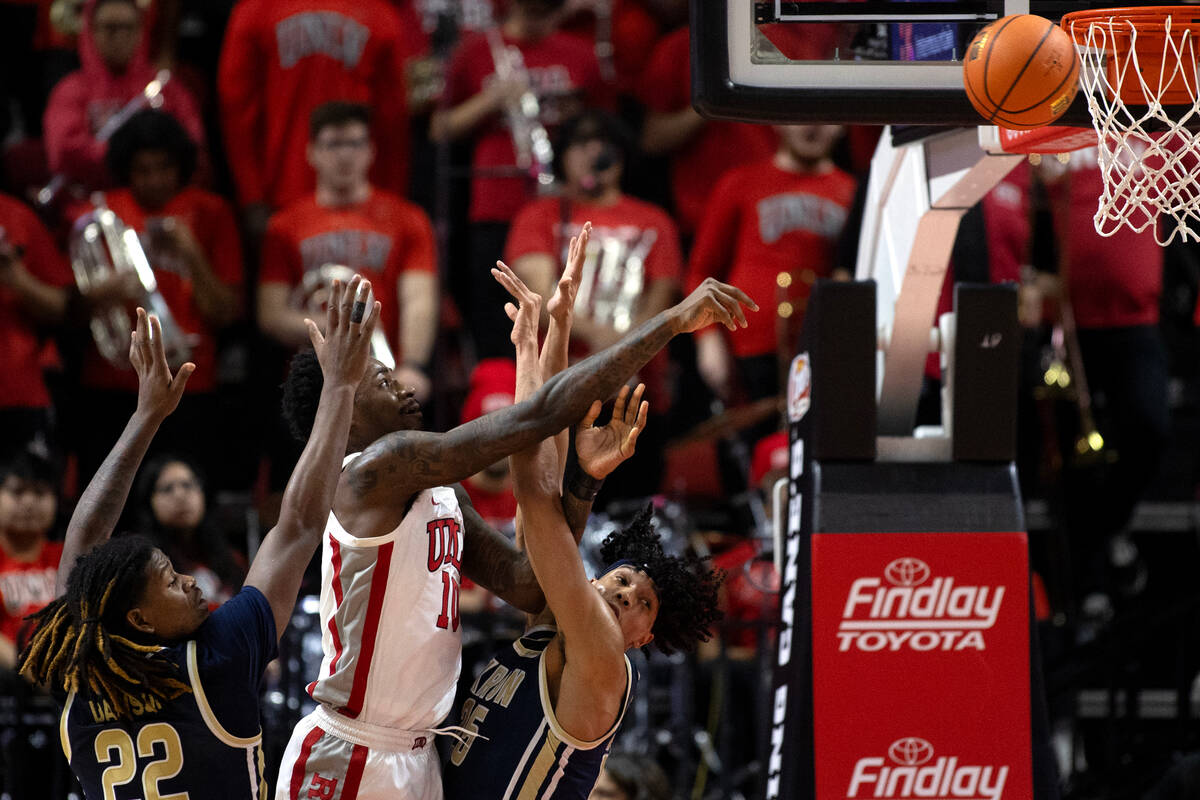 UNLV Rebels forward Kalib Boone (10) attempts a shot against Akron Zips guard Mikal Dawson (22) ...