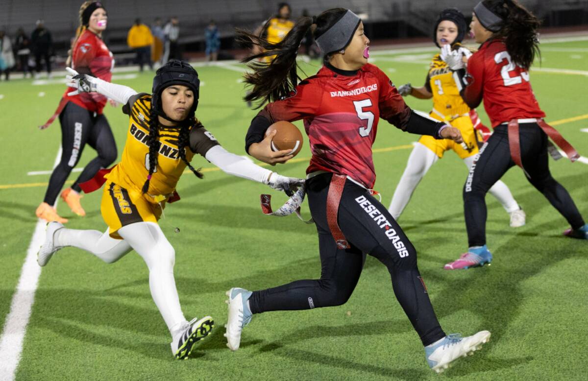 Desert Oasis quarterback Akemi Higa (5) runs the ball while Bonanza’s Larein Caballero (6) re ...