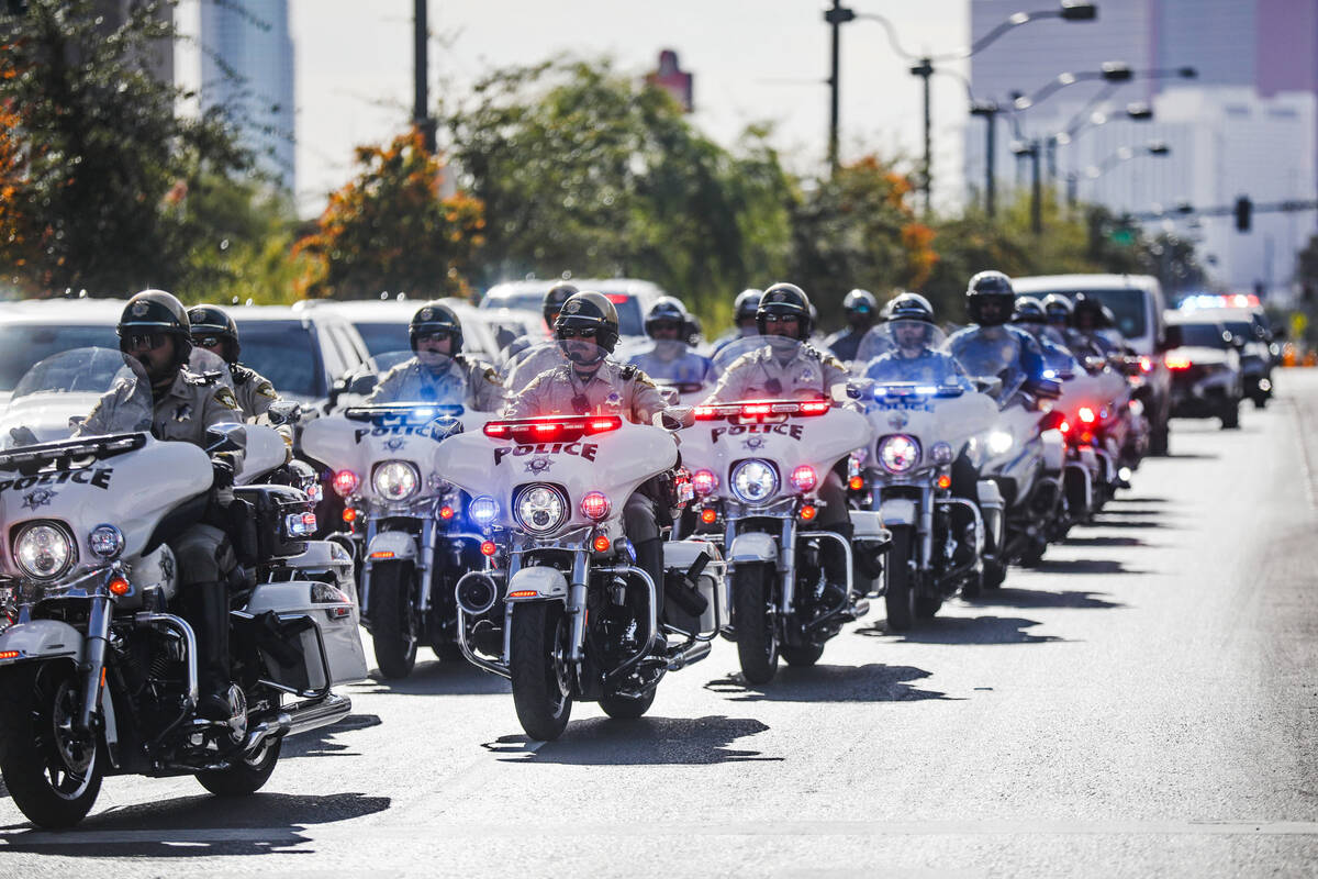 A police procession for a slain Nevada Highway Patrol trooper moves toward the coroner’s offi ...