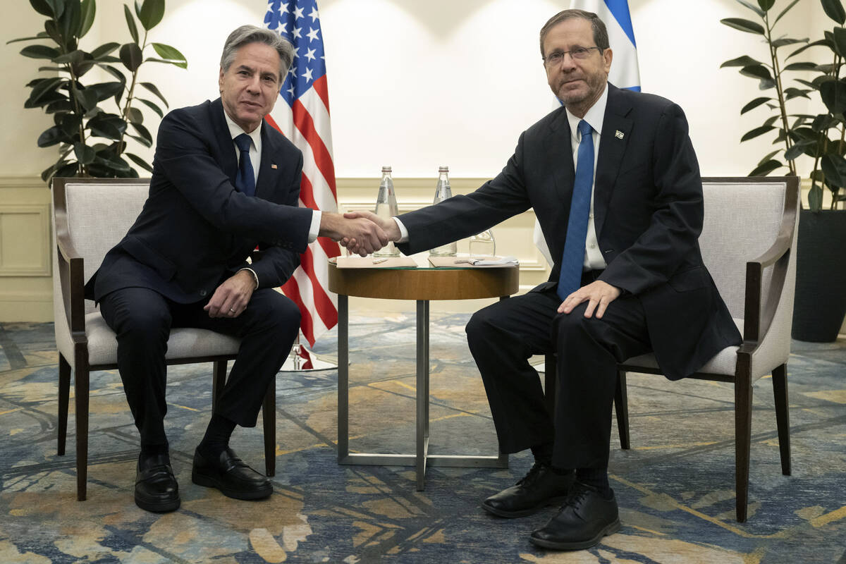 Israeli President Isaac Herzog, right, and US Secretary of State Antony Blinken shake hands dur ...