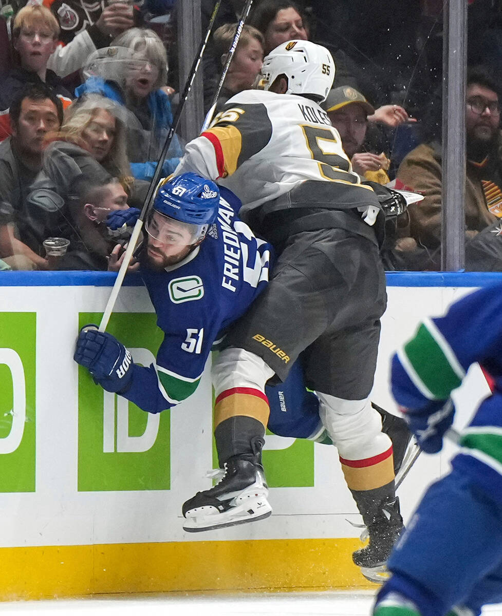 Vegas Golden Knights' Keegan Kolesar, right, checks Vancouver Canucks' Mark Friedman during the ...