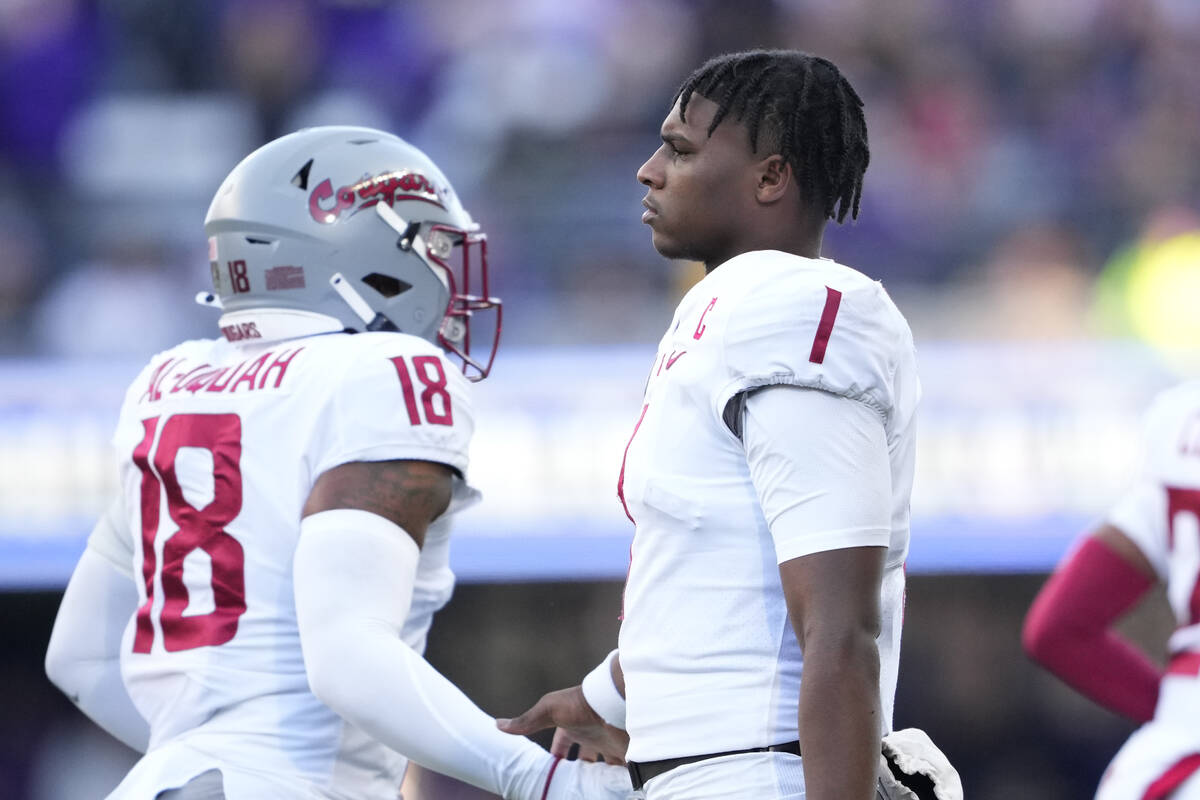 Washington State quarterback Cameron Ward (1) greets linebacker Taariq Al-Uqdah (18) during the ...