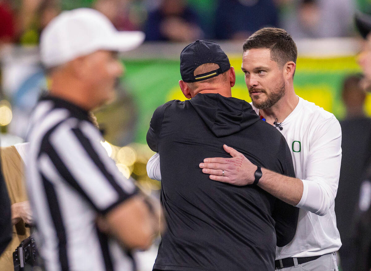 Washington Huskies head coach Kalen DeBoer hugs Oregon Ducks head coach Dan Lanning at midfield ...