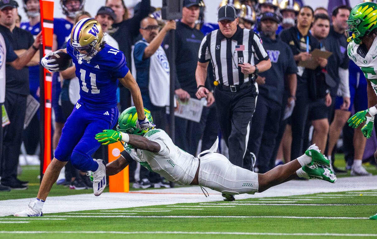 Washington Huskies wide receiver Jalen McMillan (11) looks for more yards along the sideline as ...