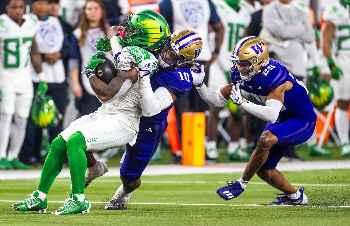 Oregon Ducks running back Bucky Irving (0) is pulled down by Washington Huskies linebacker Rale ...