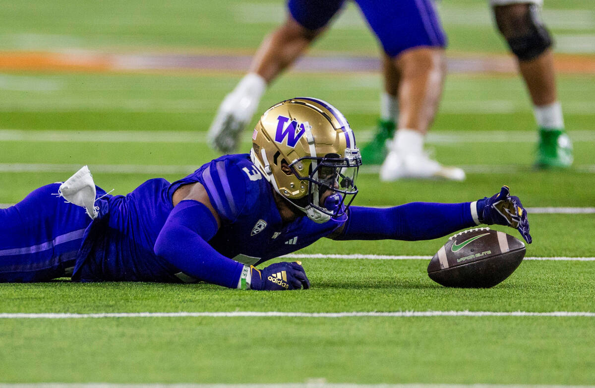 Washington Huskies safety Mishael Powell (3) scoops up a loose ball after his interception agai ...