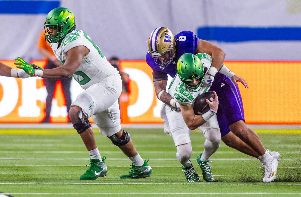 Oregon Ducks quarterback Bo Nix (10) is sacked by Washington Huskies defensive end Bralen Trice ...