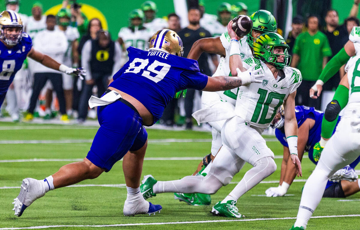 Washington Huskies defensive lineman Faatui Tuitele (99) reaches for Oregon Ducks quarterback B ...