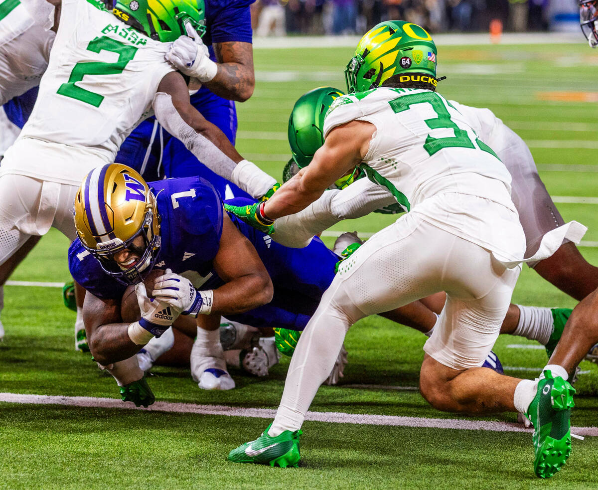 Washington Huskies running back Dillon Johnson (7) dives into the end zone as Oregon Ducks defe ...