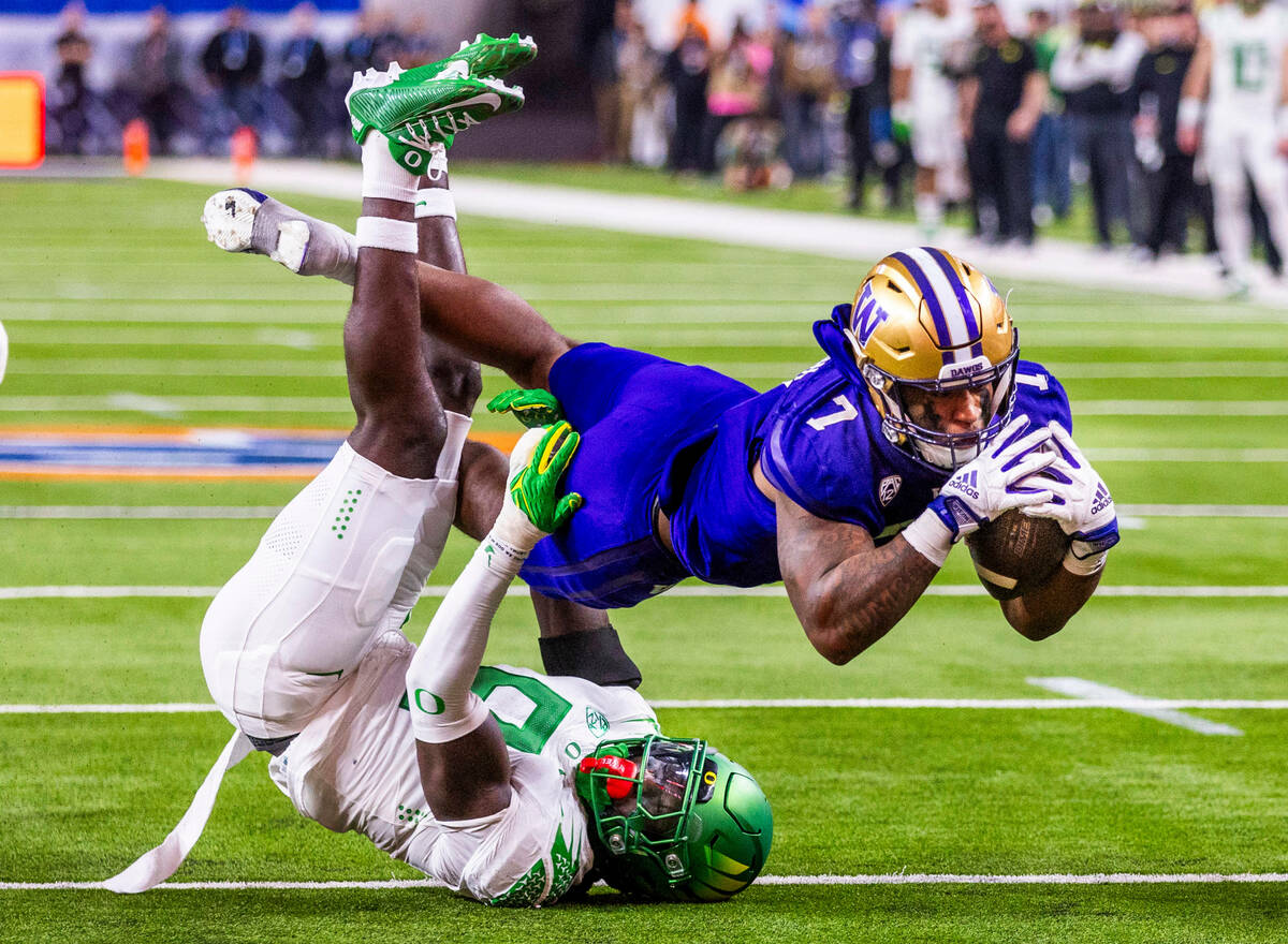 Washington Huskies running back Dillon Johnson (7) dives for the end zone as Oregon Ducks defen ...