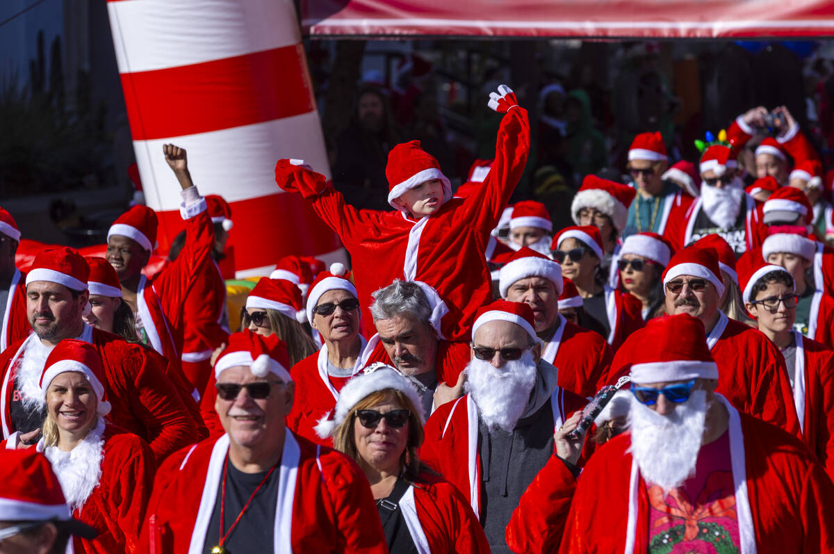 Participants in the 5K run leave the starting line during the Las Vegas Great Santa Run through ...