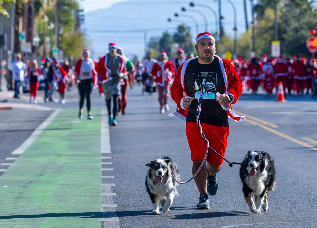 Participants in the 5K run head to the finish line during the Las Vegas Great Santa Run through ...