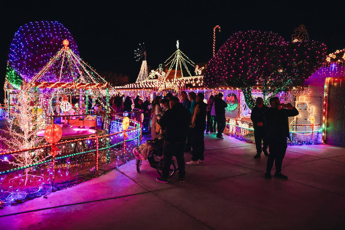 People stroll through the yard of Dale Ryan and Dyanah Musgrave on Sunday, Dec. 3, 2023, in Bou ...