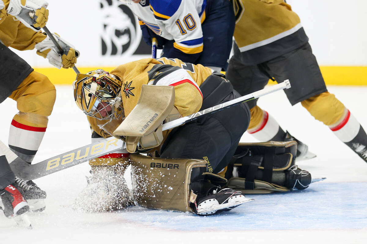 Vegas Golden Knights goaltender Logan Thompson, center bottom, makes a save against the St. Lou ...