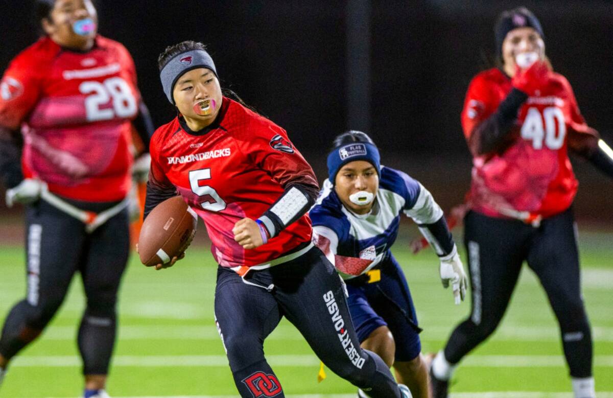 Desert Oasis quarterback Akemi Higa (5) runs for yards pas Shadow Ridge defender Jimena Barraza ...