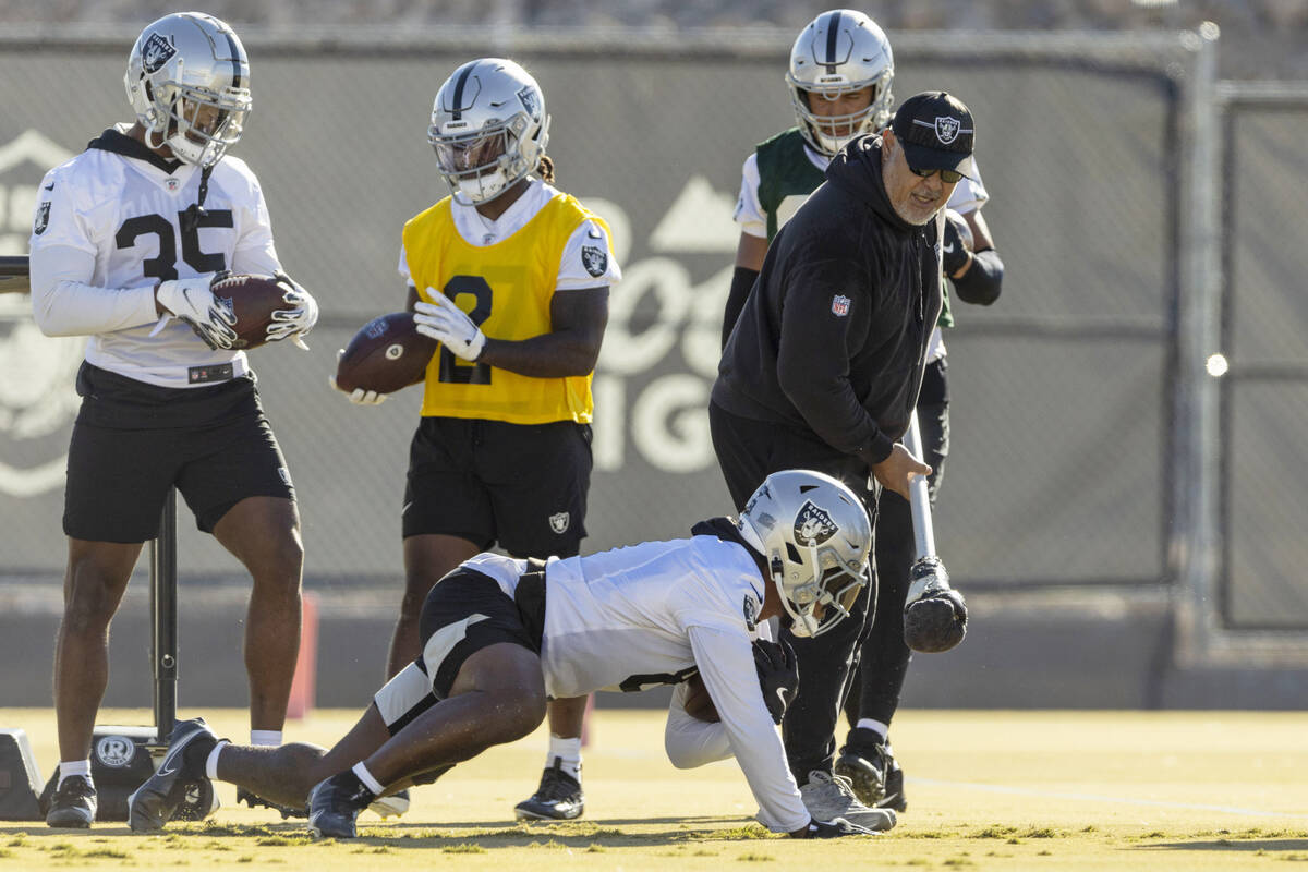 Raiders running back Josh Jacobs (8) pushes up from the ground to run with running back coach K ...