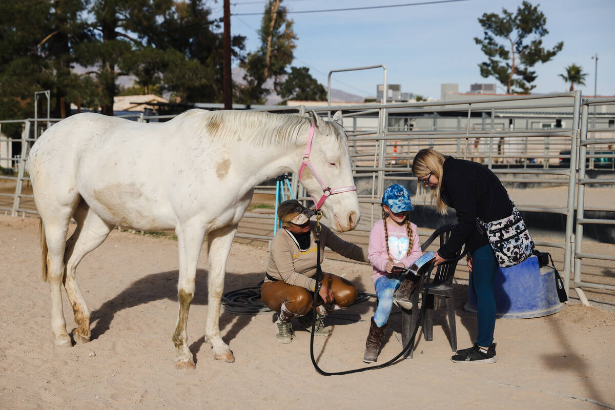 Eliora Oles, 9, reads to Lagertha with help from her mom Kelly Oles, right, and Esther Hillner, ...