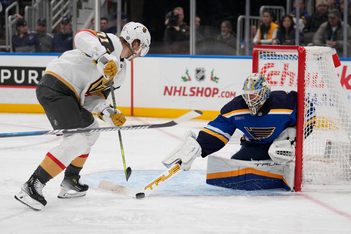 St. Louis Blues goaltender Jordan Binnington, right, deflects the puck away from Vegas Golden K ...