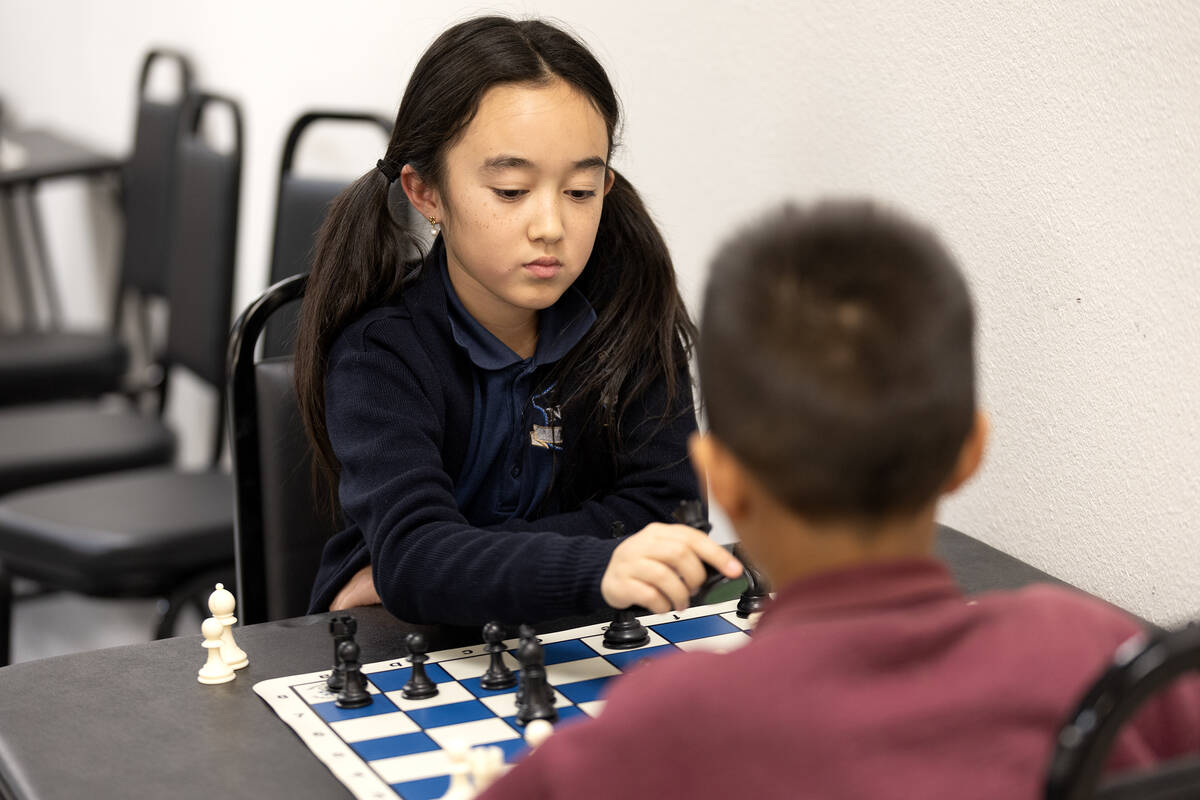 Julia Wang, 10, makes a move against Timi Guo, 8, in a chess game before their lesson at Bridge ...