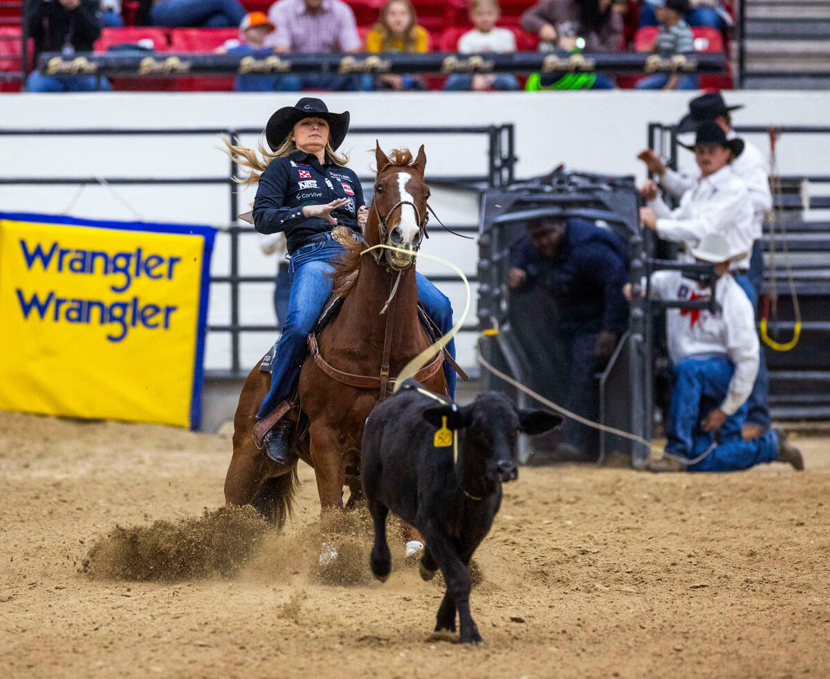 Bradi Good of Abilene, Texas, pulls back on the rope after tossing it around a calf during the ...