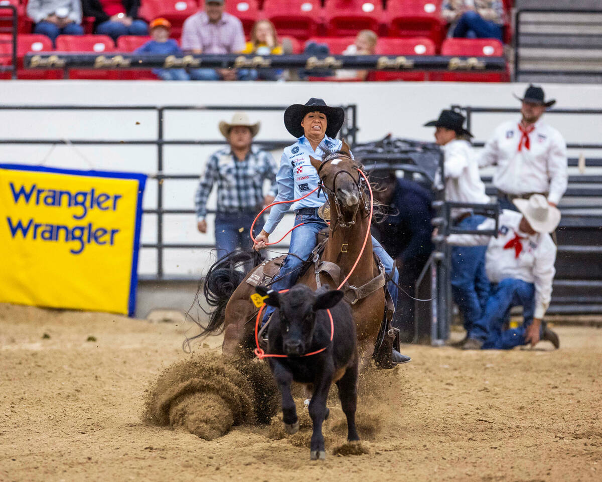 Martha Angelone of Stephenville, Texas, ropes a calf during the NFR breakaway roping challenge ...