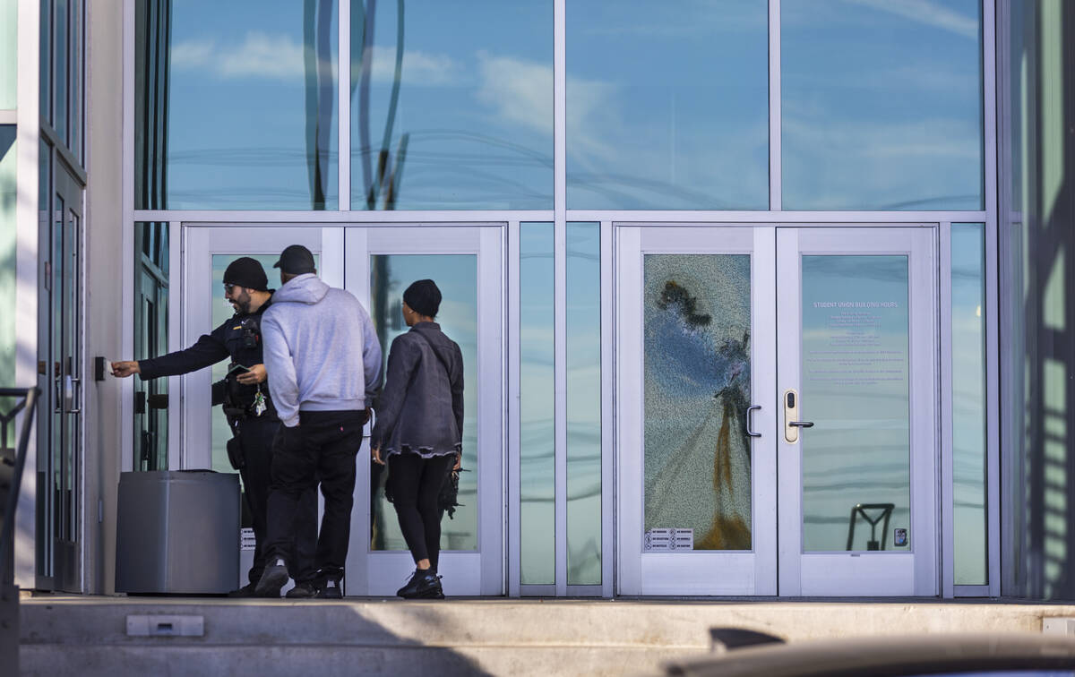 A security officer attempts to get access for several people to the Student Union following the ...