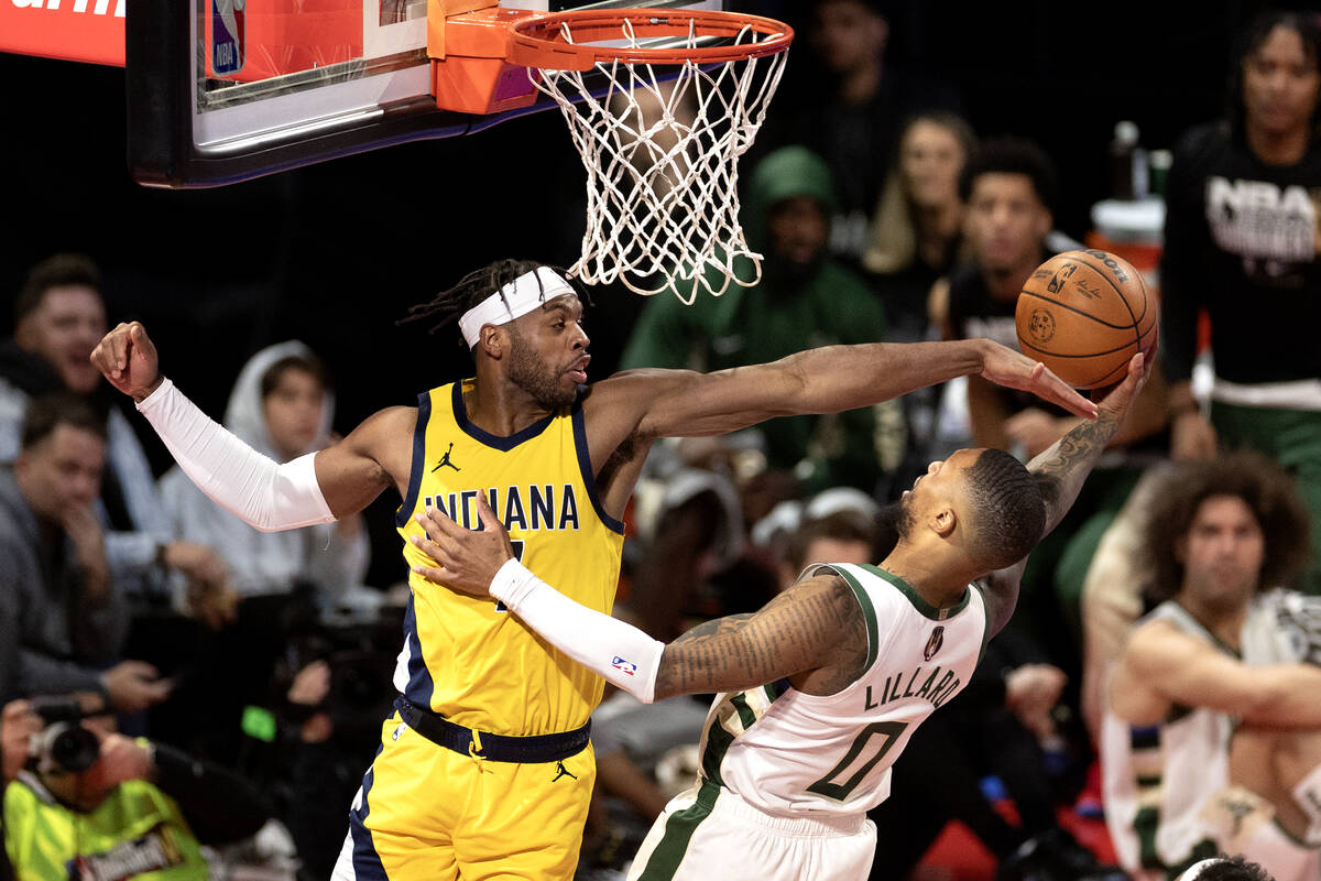 Indiana Pacers guard Buddy Hield (7) thwarts a shot by Milwaukee Bucks guard Damian Lillard (0) ...