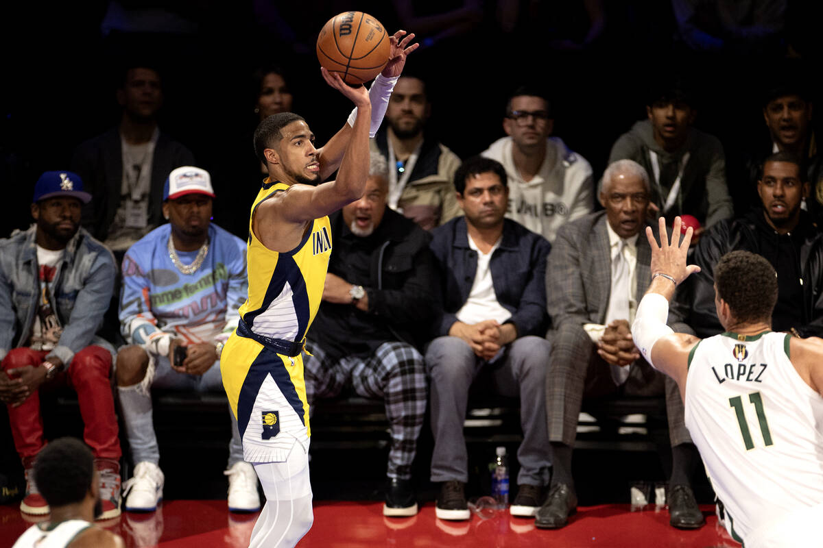 Indiana Pacers guard Tyrese Haliburton (0) shoots abasing Milwaukee Bucks center Brook Lopez (1 ...