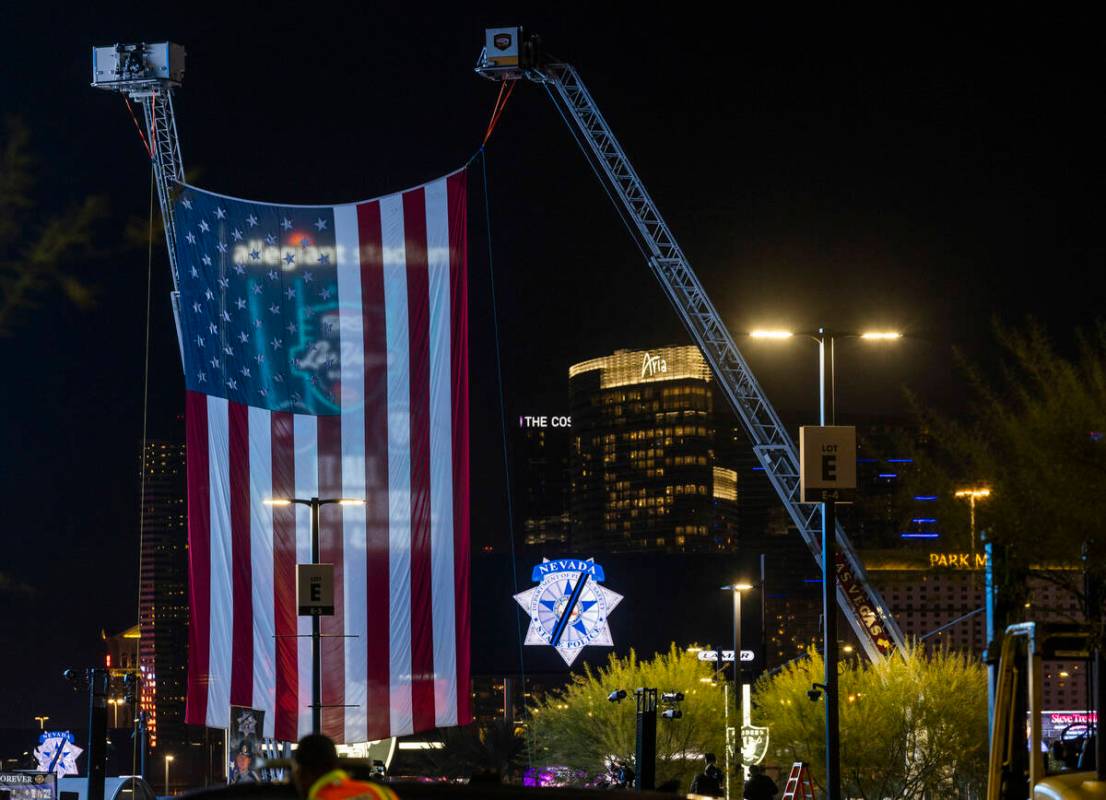 A large American flag is suspended from firetrucks dedicated to Nevada Highway Patrol troopers ...