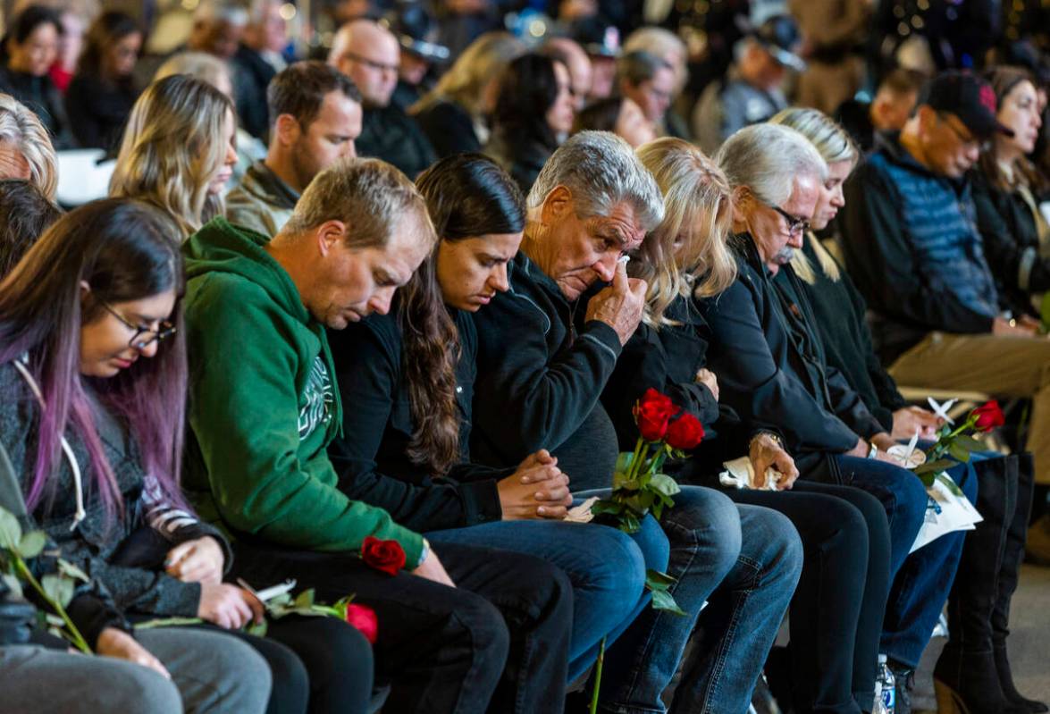 Family members and supporters take in the opening prayer during a candlelight vigil for Nevada ...