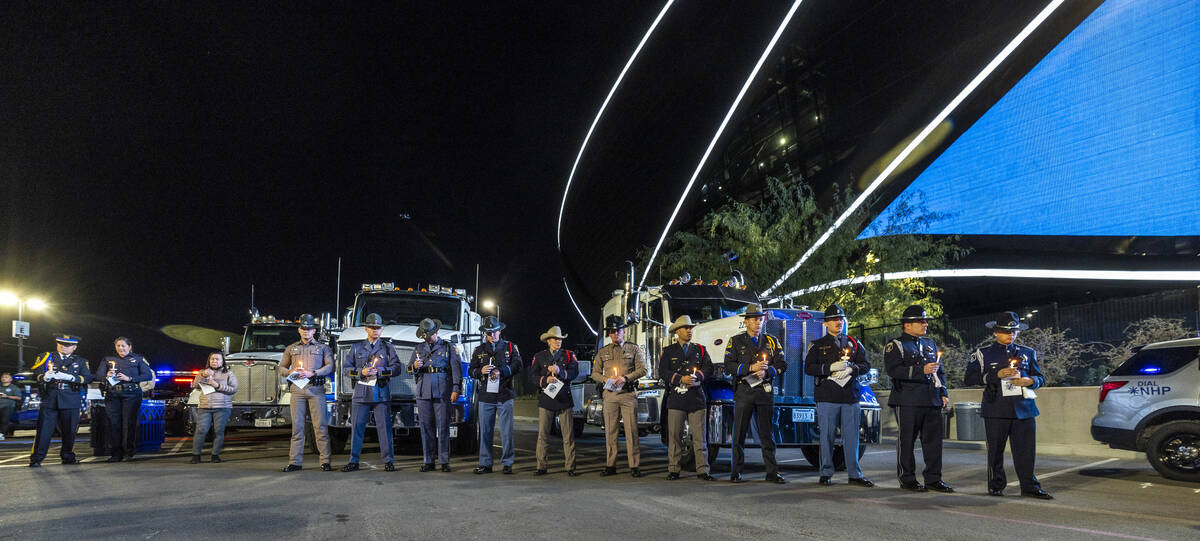 Law enforcement officers stand together during a candlelight vigil for Nevada Highway Patrol tr ...