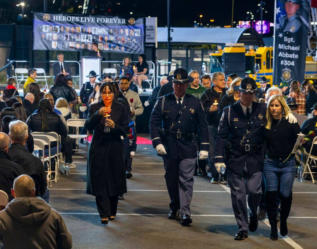 Trooper's wives Arlene Felix and Vanessa Abbate are escorted out with lit candles following a c ...