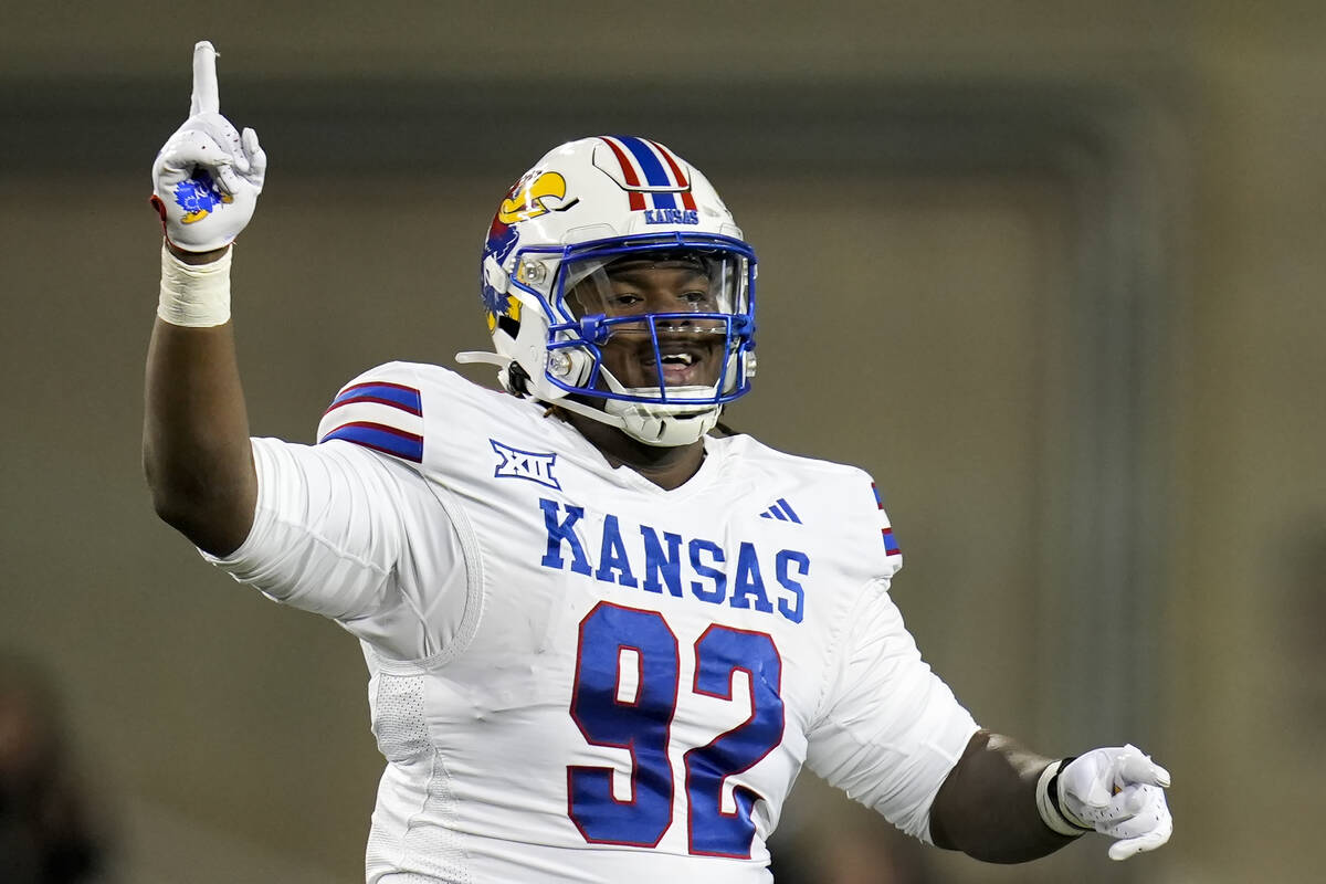 Kansas defensive lineman Tommy Dunn Jr. (92) celebrates after cornerback Cobee Bryant (2) inter ...