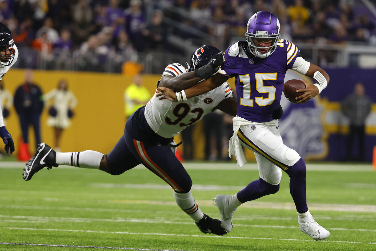 Minnesota Vikings quarterback Joshua Dobbs (15) runs from Chicago Bears defensive tackle Justin ...